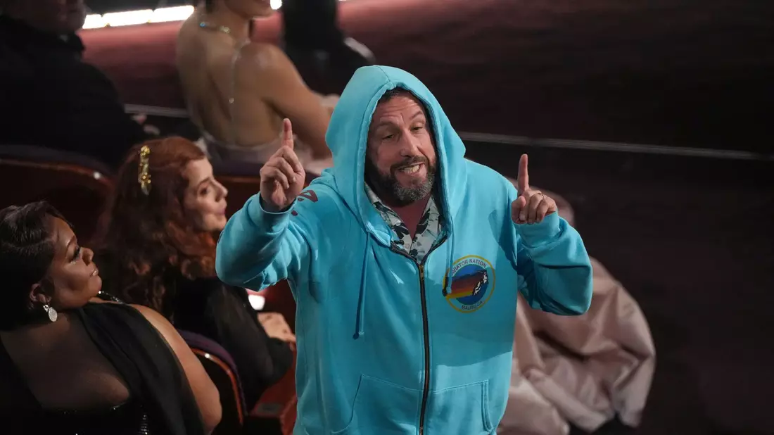 Adam Sandler saß in Sweatshirt-Jacke und Shorts im Publikum. - Bild: Chris Pizzello/Invision/AP/dpa