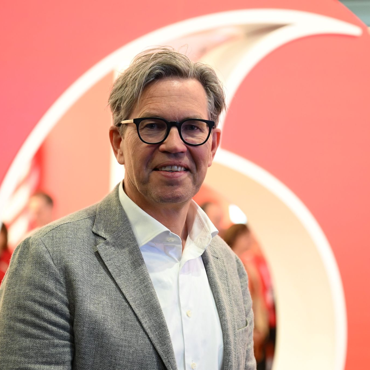 Vodafone-Deutschlandchef Marcel de Groot vor einem großen Plastik-Logo seiner Firma. - Foto: Wolf von Dewitz/dpa