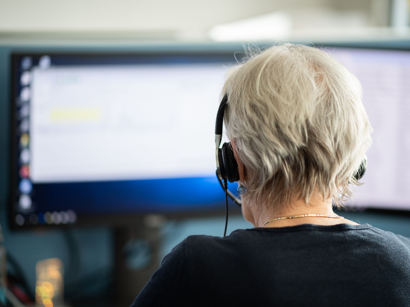 Eine Mitarbeiterin arbeitet in einer Telefonzentrale. (Archivbild) - Foto: Daniel Reinhardt/dpa