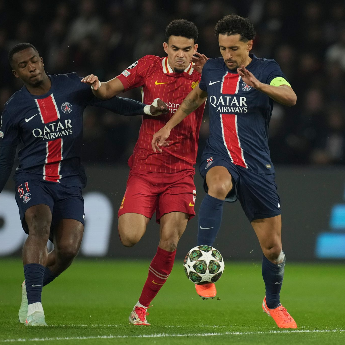 Nicht nur Liverpools Luis Diaz (M) hatte gegen die Pariser Willian Pacho (l) und Marquinhos mächtig Probleme.   - Foto: Christophe Ena/AP/dpa