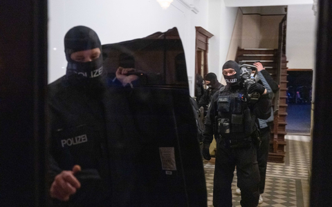 Nach Gewalt an einem Sonderzug von Fans: Polizisten gehen bei einem Einsatz in eine Wohnung - Foto: Christophe Gateau/dpa