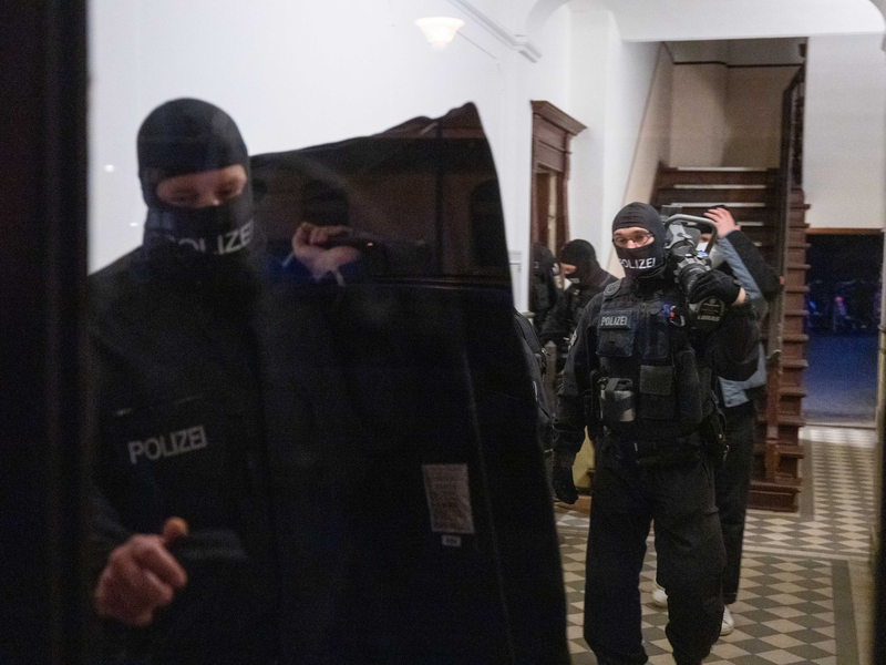 Nach Gewalt an einem Sonderzug von Fans: Polizisten gehen bei einem Einsatz in eine Wohnung - Foto: Christophe Gateau/dpa