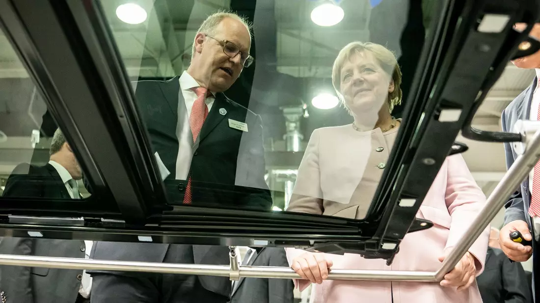 Der scheidende Webasto-Chef Holger Engelmann in besseren Tagen im Jahr 2019. Hier demonstriert der Manager der früheren Bundeskanzlerin Angela Merkel in einem Werk im chinesischen Wuhan die Fertigung von Schiebedächern. - Bild: Michael Kappeler/dpa