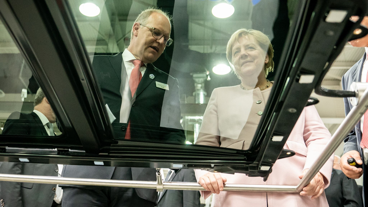 Der scheidende Webasto-Chef Holger Engelmann in besseren Tagen im Jahr 2019. Hier demonstriert der Manager der früheren Bundeskanzlerin Angela Merkel in einem Werk im chinesischen Wuhan die Fertigung von Schiebedächern. - Foto: Michael Kappeler/dpa