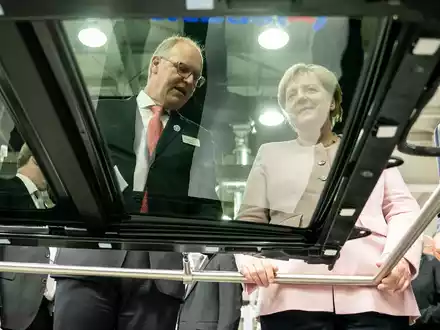 Der scheidende Webasto-Chef Holger Engelmann in besseren Tagen im Jahr 2019. Hier demonstriert der Manager der früheren Bundeskanzlerin Angela Merkel in einem Werk im chinesischen Wuhan die Fertigung von Schiebedächern. - Foto: Michael Kappeler/dpa