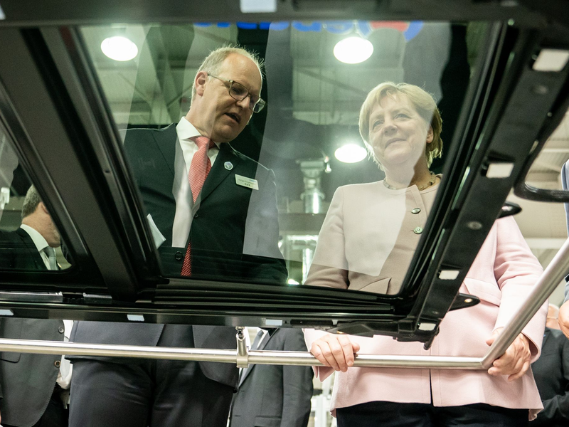 Der scheidende Webasto-Chef Holger Engelmann in besseren Tagen im Jahr 2019. Hier demonstriert der Manager der früheren Bundeskanzlerin Angela Merkel in einem Werk im chinesischen Wuhan die Fertigung von Schiebedächern. - Foto: Michael Kappeler/dpa