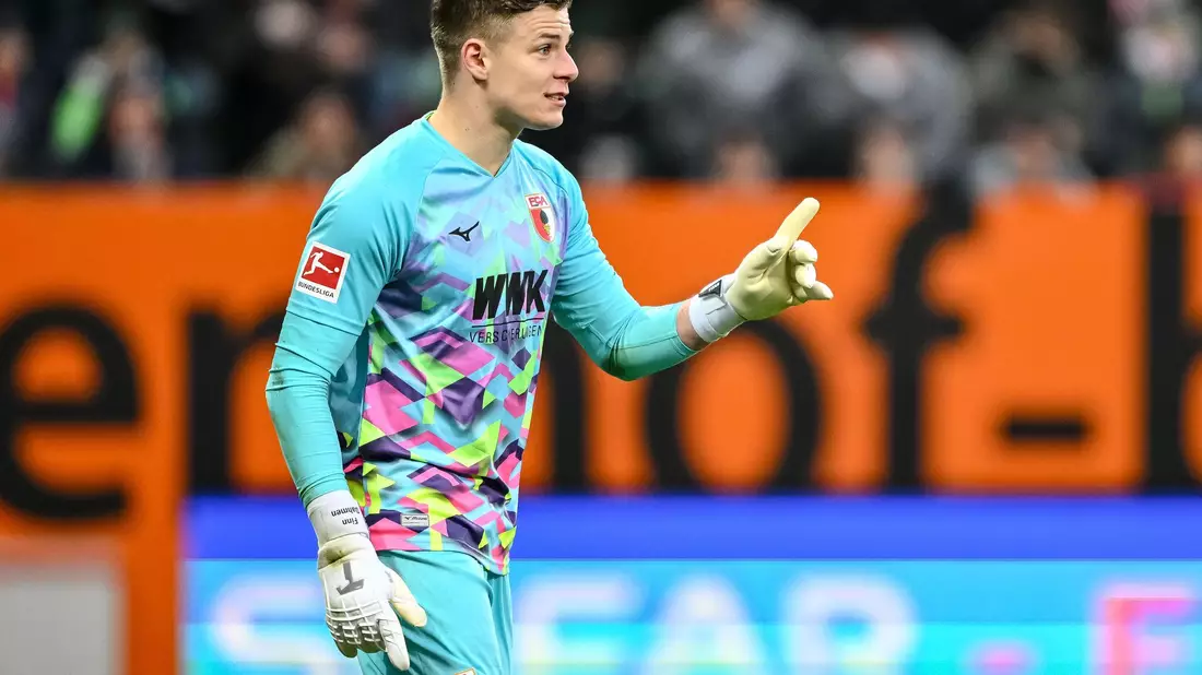 Augsburgs Marius Wolf spielt den Ball an Joakim Maehle von Wolfsburg vorbei. - Bild: Harry Langer/dpa