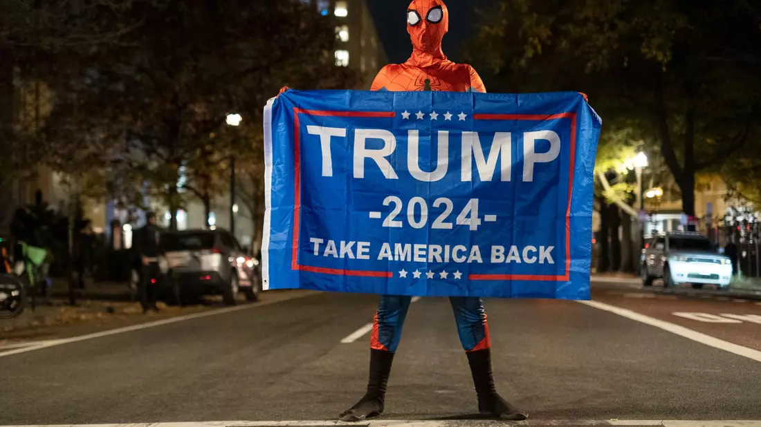 Trump-Unterstützer im Spider-Man-Kostüm mit einem Trump-Transparent am Tag der US-Präsidentschaftswahl 2024 in Washington. - Bild: Probal Rashid/ZUMA Press Wire/dpa