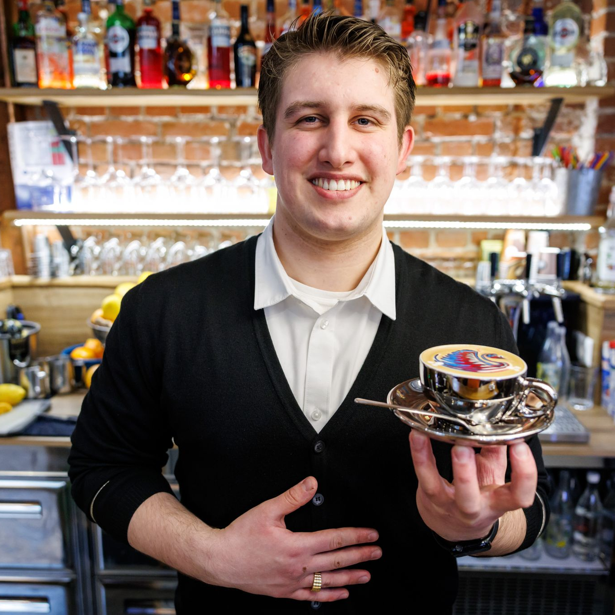 Ihm kann es nicht zu bunt sein: Bozzato bereitet den kunstvollen Milchschaum im Kaffee im Familienbetrieb zu. - Foto: Daniel Karmann/dpa