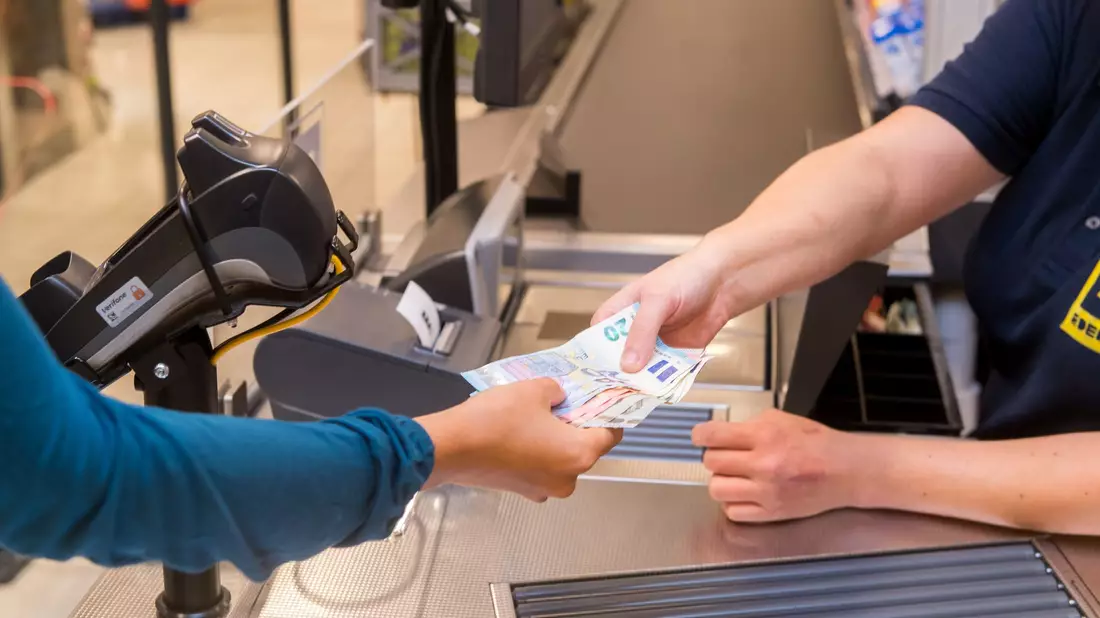 In einem Supermarkt hebt eine Kundin beim Bezahlen auch gleich Bargeld ab. - Bild: Benjamin Nolte/dpa