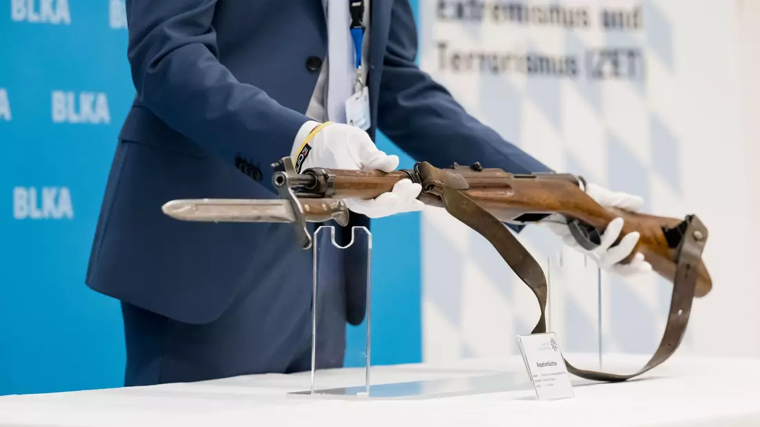 Ein 18 Jahre alter Österreicher hatte am 5. September 2024 mit einem Repetiergewehr aus ehemaligen Schweizer Armee-Beständen auf das Konsulat in der bayerischen Landeshauptstadt geschossen sowie auf das NS-Dokumentationszentrum in der Nähe. Er starb nach einem Schusswechsel mit Polizisten. Ein Polizeibeamter zeigt bei einer Pressekonferenz die Tatwaffe, eine Repetierbüchse aus Schweizer Fertigung (Karabiner 31). Ermittler werten die Schüsse auf das Generalkonsulat als antiisraelischen Terroranschlag. (Archivfoto) - Bild: Tobias Hase/dpa