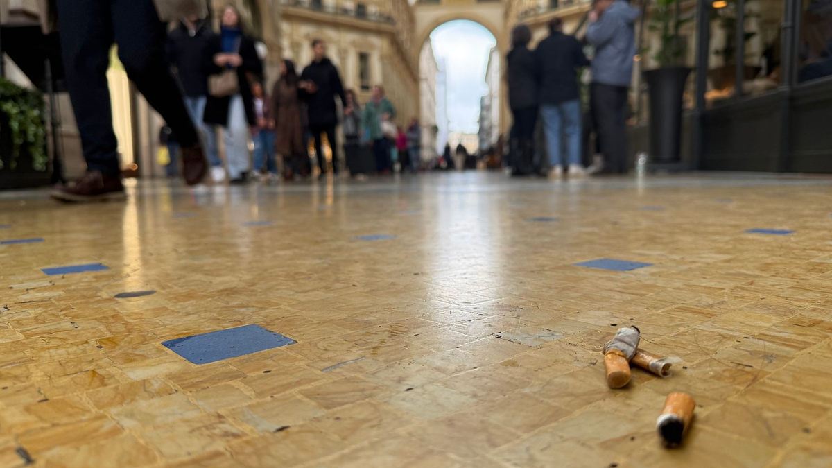 Eine Touristin mit Zigarette in der Hand vor dem Dom in Mailand. - Foto: Christoph Sator/dpa
