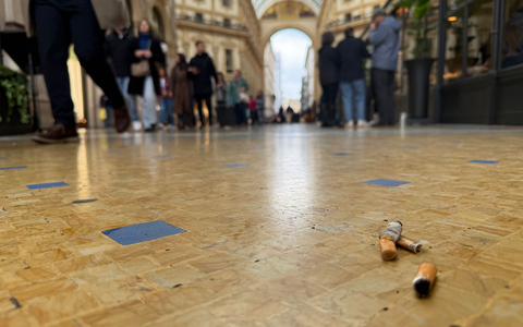 Eine Touristin mit Zigarette in der Hand vor dem Dom in Mailand. - Foto: Christoph Sator/dpa