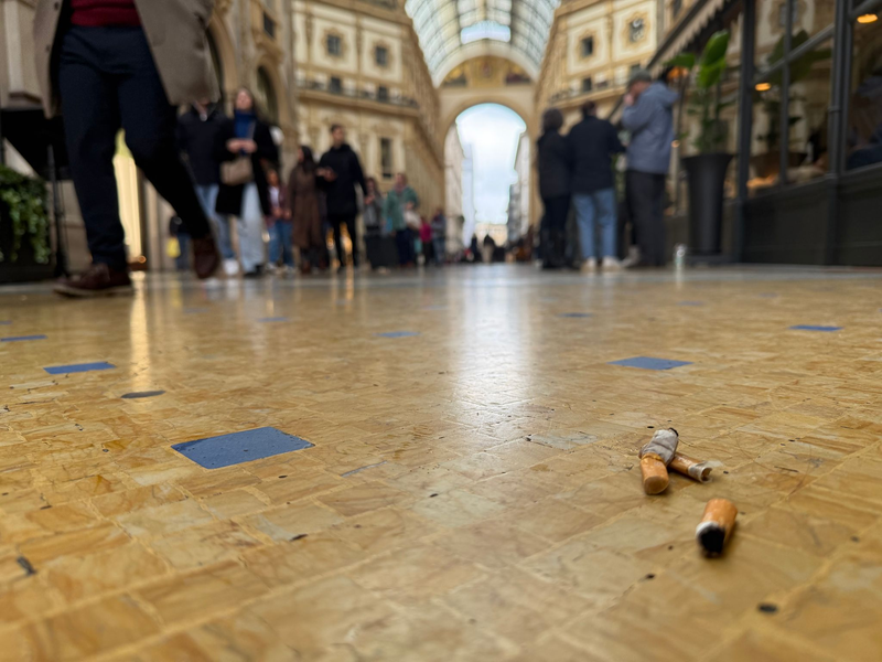 Eine Touristin mit Zigarette in der Hand vor dem Dom in Mailand. - Foto: Christoph Sator/dpa