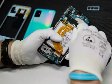 In einer Werkstatt wird ein altes Smartphone wiederaufbereitet.  - Foto: Sebastian Willnow/dpa-Zentralbild/dpa