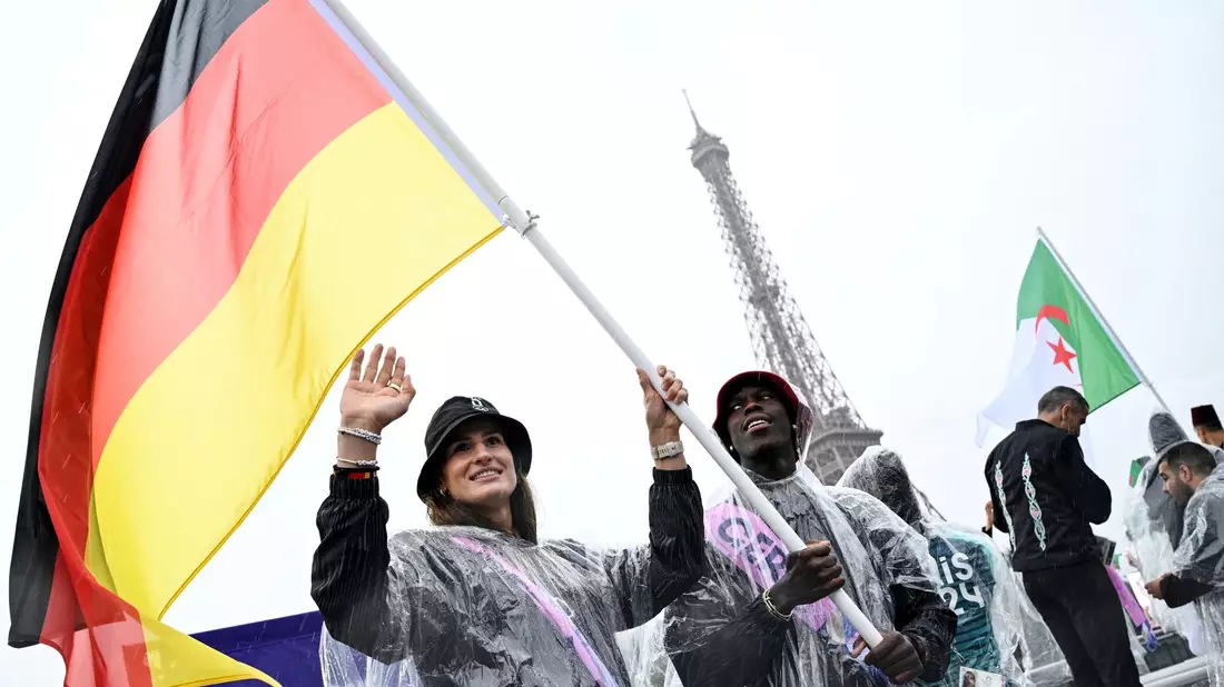 Große Ehre: Anna-Maria Wagner als Fahnenträgerin neben Basketball-Star Dennis Schröder. - Bild: Annegret Hilse/REUTERS Pool/AP/dpa/dpa