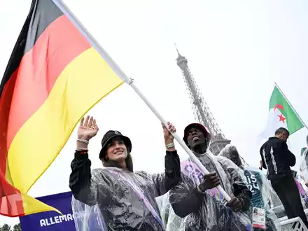 Große Ehre: Anna-Maria Wagner als Fahnenträgerin neben Basketball-Star Dennis Schröder. - Foto: Annegret Hilse/REUTERS Pool/AP/dpa/dpa