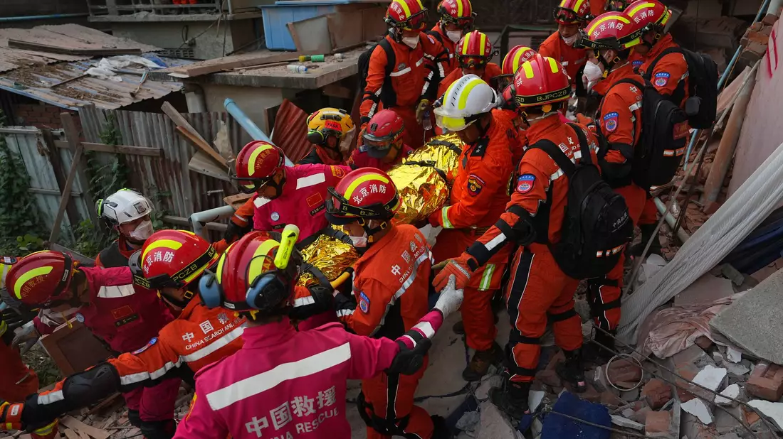Rettungskräfte befreien einen Überlebenden unter Trümmern.  - Bild: Cai Yang/XinHua/dpa