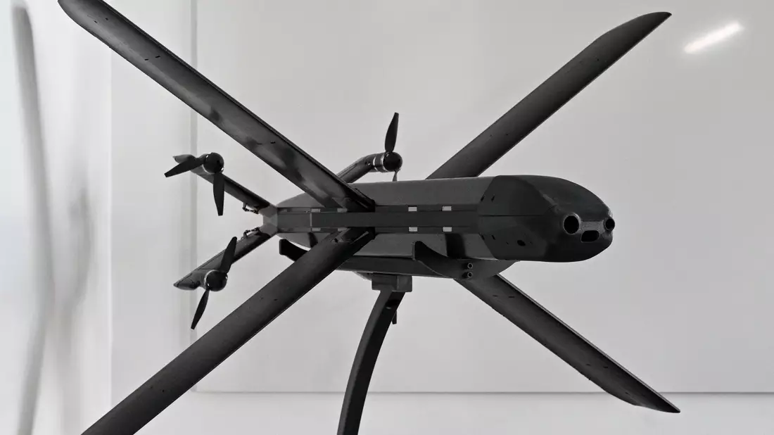 Ein Modell der HX-2-Drohne von Helsing, daneben der Mitgründer und Co-Firmenchef Gundbert Scherf. - Bild: Jens Kalaene/dpa