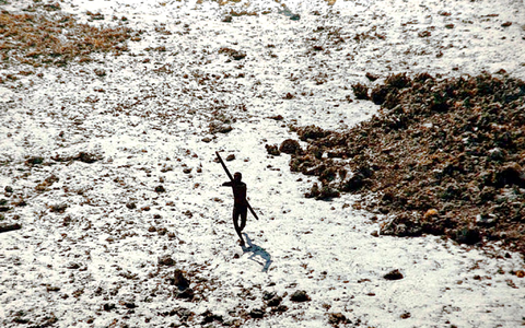 Ein Bewohner der für Außenstehende verbotenen indischen Insel North Sentinel zielt mit Pfeil und Bogen. (Foto Archiv - Foto: -/Indian Coastguard/Survival International/dpa