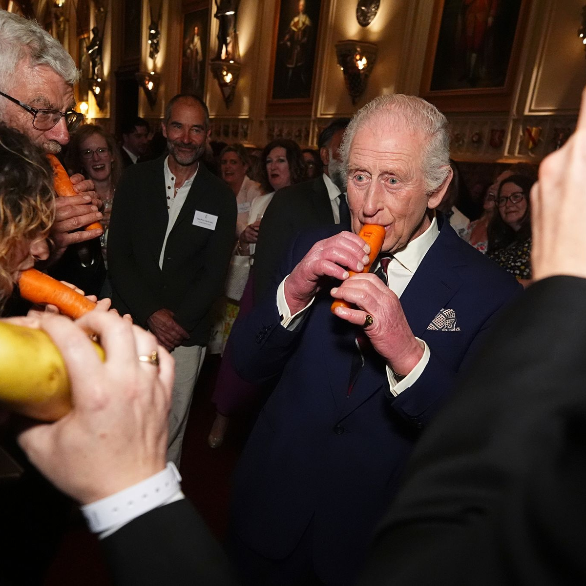 König Charles III. versuchte sich an der Karottenflöte. - Foto: Aaron Chown/PA Pool/AP/dpa
