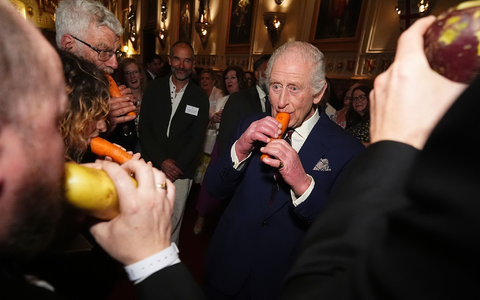 König Charles III. versuchte sich an der Karottenflöte. - Foto: Aaron Chown/PA Pool/AP/dpa