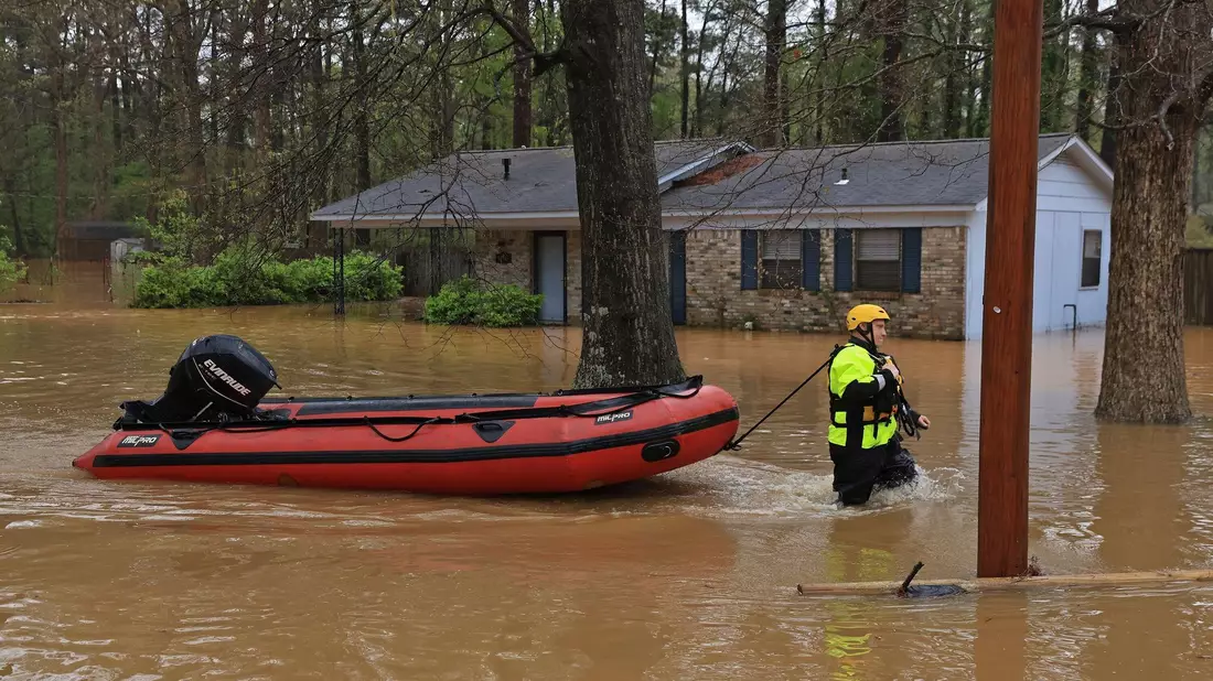 Teilweise kamen die Rettungskräfte nur noch per Boot voran. - Bild: Colin Murphey/Arkansas Democrat-Gazette/AP/dpa