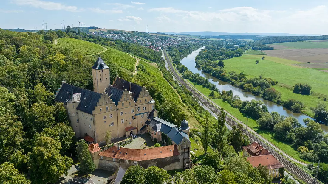Sommerlicher Blick auf Schloss Mainberg bei Schweinfurt (Luftaufnahme mit einer Drohne). Die Gemeinde Schonungen in der Nähe von Schweinfurt sucht einen neuen Besitzer für das Schloss Mainberg, in dem Gunter Sachs geboren wurde. - Bild: -/DSK Deutsche Stadt- und Grundstücksentwicklungsgesellschaft mbH/dpa