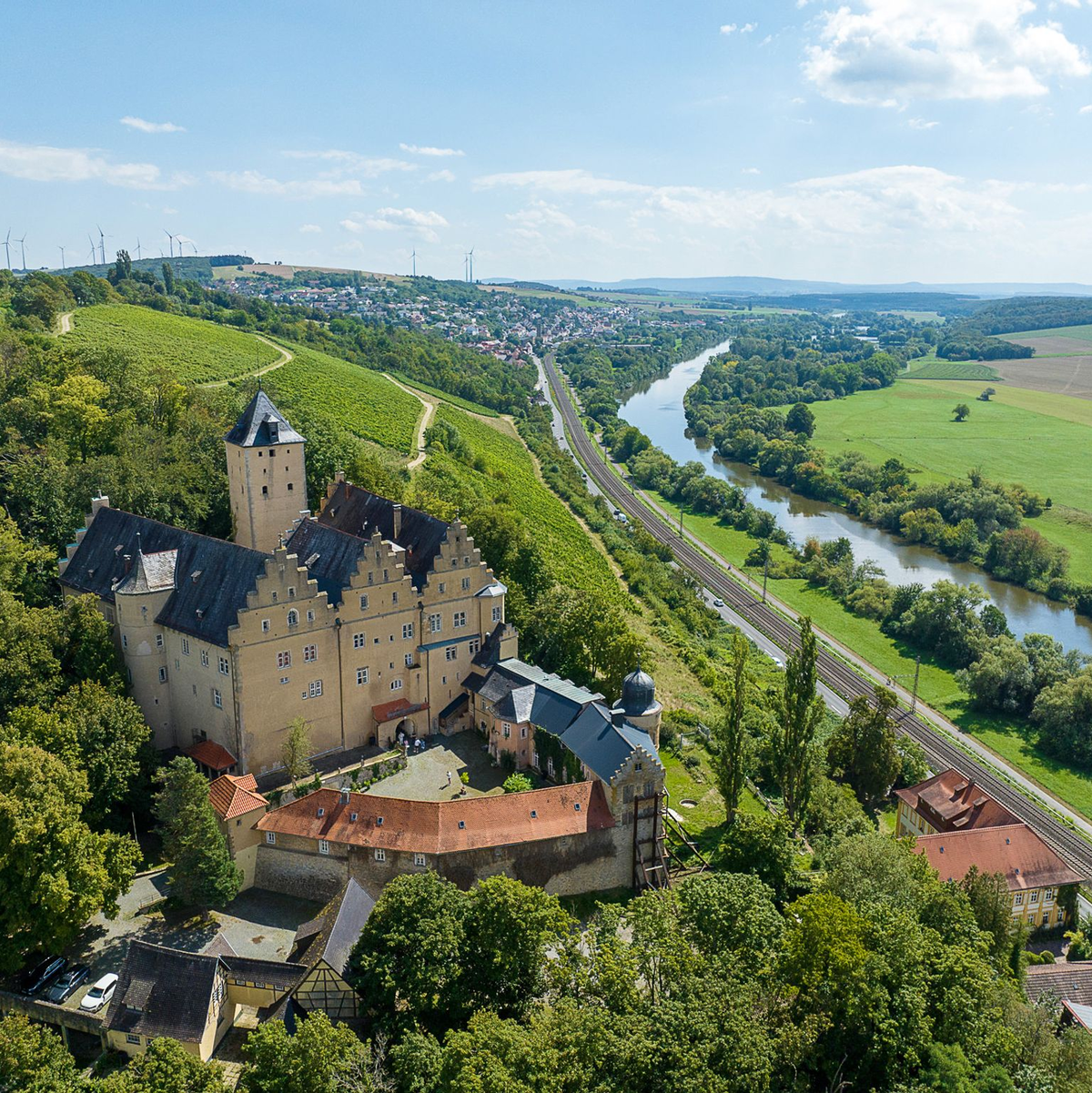 Sommerlicher Blick auf Schloss Mainberg bei Schweinfurt (Luftaufnahme mit einer Drohne). Die Gemeinde Schonungen in der Nähe von Schweinfurt sucht einen neuen Besitzer für das Schloss Mainberg, in dem Gunter Sachs geboren wurde. - Foto: -/DSK Deutsche Stadt- und Grundstücksentwicklungsgesellschaft mbH/dpa
