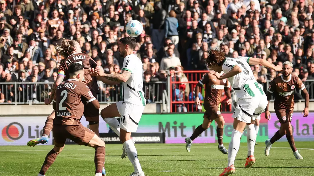 Möchengladbachs Franck Honorat (vorn) behauptet den Ball gegen die Hamburger Lars Ritzka (l) und Hauke Wahl. - Bild: Christian Charisius/dpa