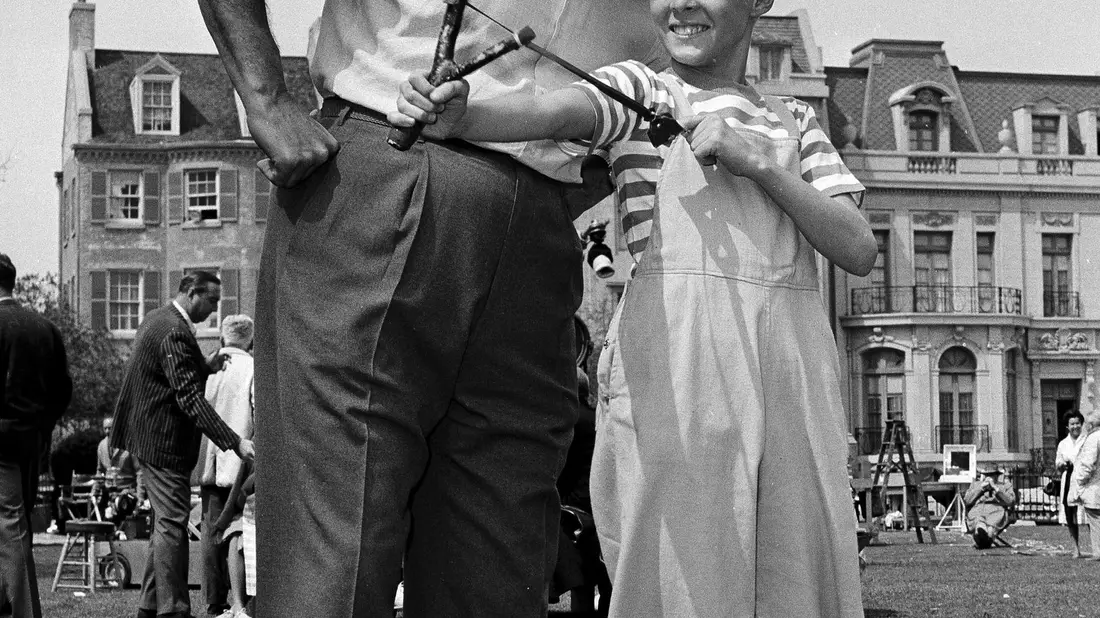 Der Schauspieler Jay North ist tot - hier ist er als Dennis am Set in Hollywood mit einer Schleuder und dem Schauspieler Gale Gordon zu sehen. (Archivbild von 1962) - Bild: David F. Smith/AP/dpa