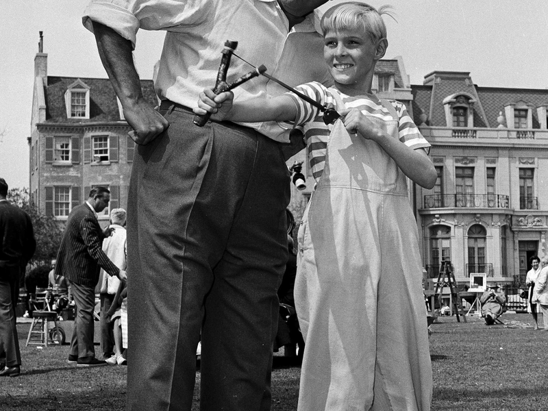 Der Schauspieler Jay North ist tot - hier ist er als Dennis am Set in Hollywood mit einer Schleuder und dem Schauspieler Gale Gordon zu sehen. (Archivbild von 1962) - Foto: David F. Smith/AP/dpa