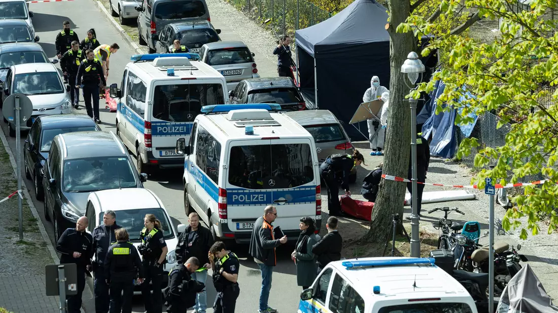 Polizisten und Beamte der Spurensicherung in weißen Schutzanzügen stehen an dem Ort, wo ein toter Mann gefunden wurde.  - Bild: Hannes P. Albert/dpa