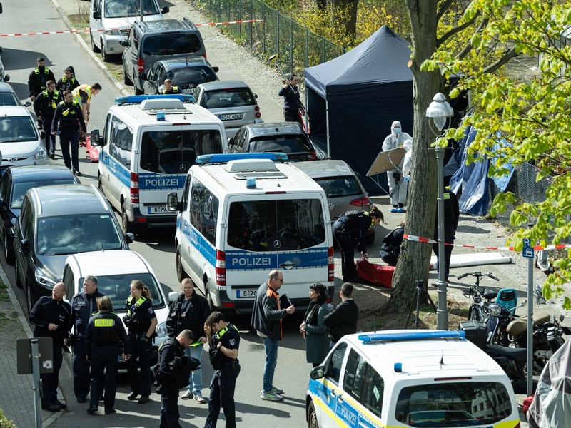 Polizisten und Beamte der Spurensicherung in weißen Schutzanzügen stehen an dem Ort, wo ein toter Mann gefunden wurde. - Foto: Hannes P. Albert/dpa