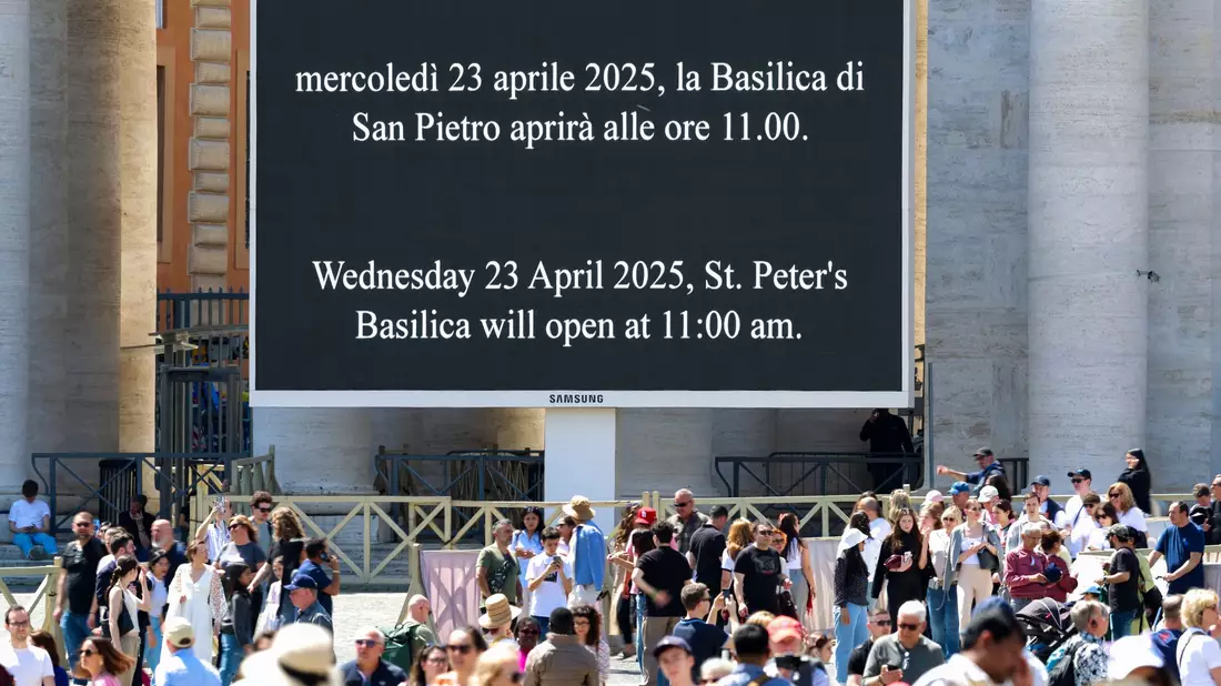 Vor dem Petersdom wird Gläubigen mitgeteilt, am wann sie den aufgebahrten Papst Franziskus sehen können. - Bild: Christoph Reichwein/dpa