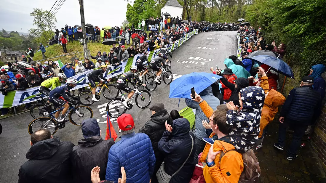 Olympiasieger Remco Evenepoel (M) mit goldenem Helm an der Mauer von Huy. Rechts neben ihm Tadej Pogacar. - Bild: Jasper Jacobs/Belga/dpa