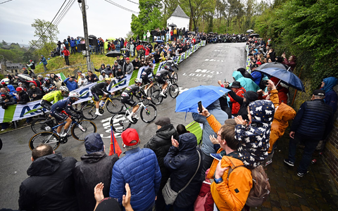 Olympiasieger Remco Evenepoel (M) mit goldenem Helm an der Mauer von Huy. Rechts neben ihm Tadej Pogacar. - Foto: Jasper Jacobs/Belga/dpa