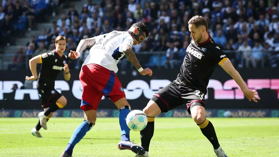 Der Hamburger SV und Davie Selke (l) patzen gegen Karlsruhe mit Christoph Kobald. - Bild: Christian Charisius/dpa