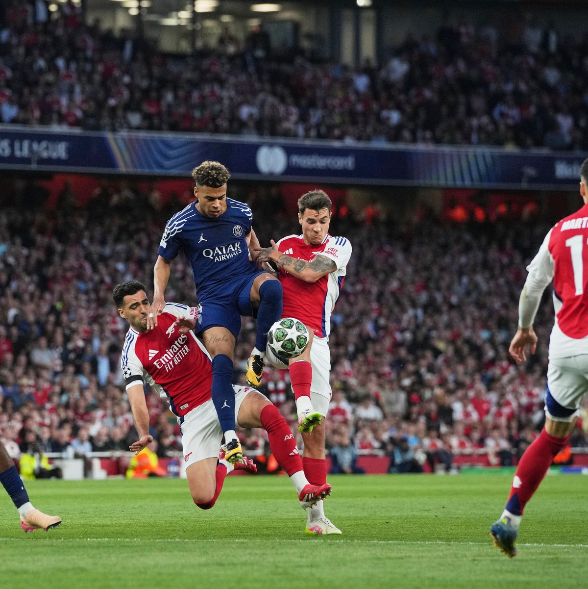 Umkämpftes Halbfinale: Desire Doué (M, l) und Gabriel Martinelli (M, r) im Duell um den Ball.   - Foto: Kin Cheung/AP/dpa