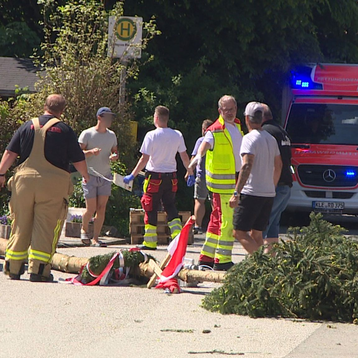 Der umgestürzte Maibaum liegt auf der Straße vor einem Einsatzwagen der Feuerwehr.  - Foto: Guido Schulmann/TV-Niederrhein/dpa