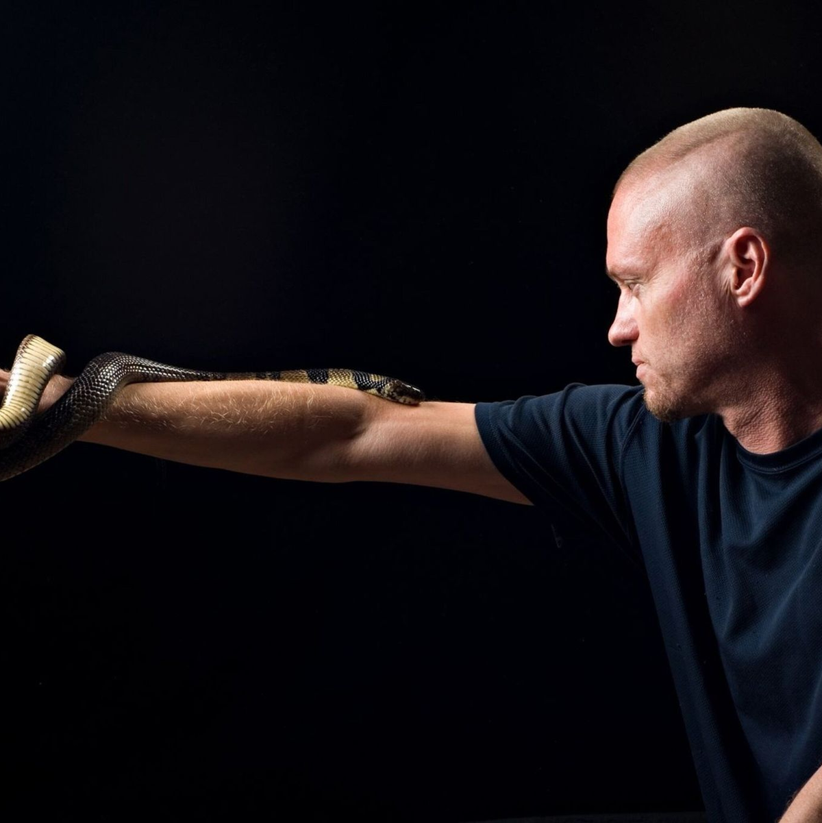 Der von Schlangen begeisterte US-Amerikaner Tim Friede hat sich selbst immer größere Dosierungen von Schlangengiften verabreicht und kann nun einfach so eine Wasserkobra auf dem Arm tragen.  - Foto: ---/Centivax/dpa