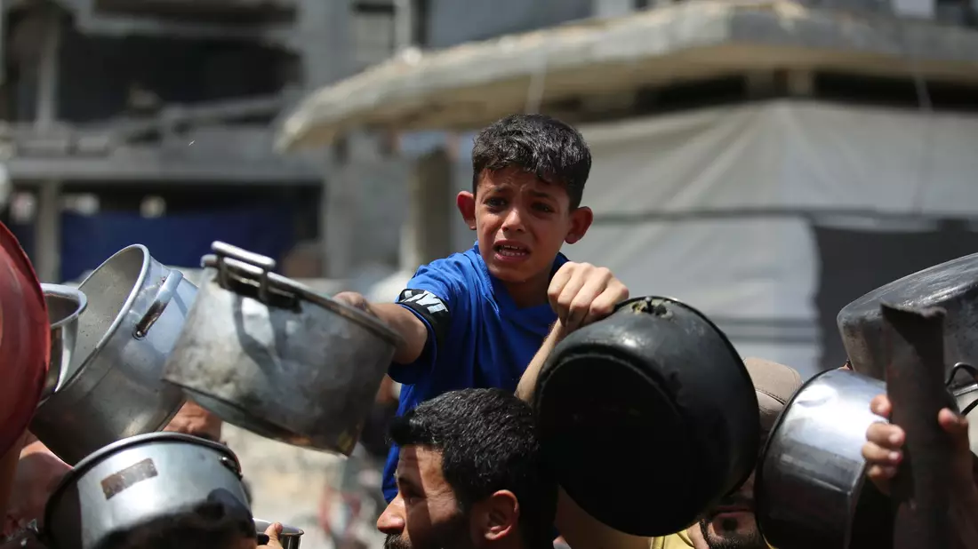 Kinder im Gazastreifen warten auf warmes Essen.  - Bild: Omar Ashtawy/APA Images via ZUMA Press Wire/dpa