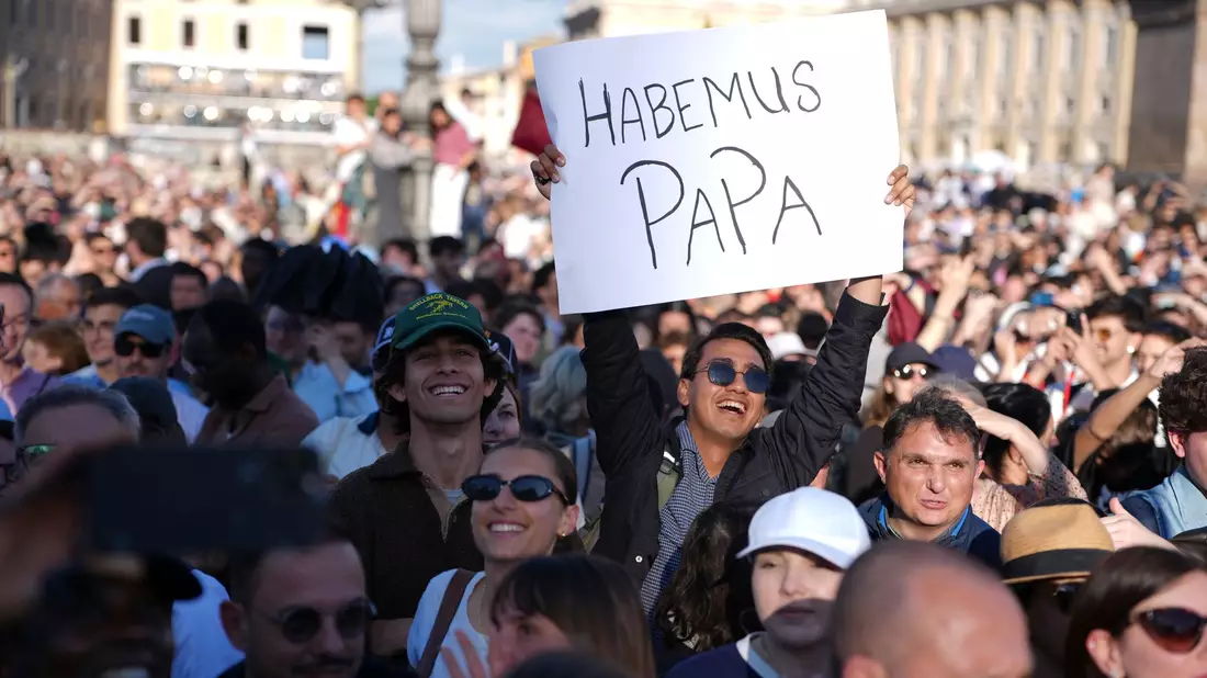Gläubige telefonieren mit ihren Angehörigen, um vom neuen Papst zu berichten. - Bild: Emilio Morenatti/AP/dpa