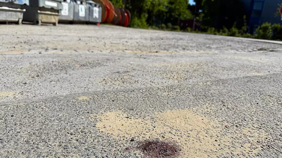 Ein Blutfleck auf dem Asphalt am Tatort lässt erahnen, was sich hier abgespielt haben könnte  - Bild: Alex Talash/dpa