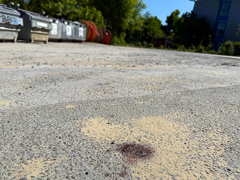 Ein Blutfleck auf dem Asphalt am Tatort lässt erahnen, was sich hier abgespielt haben könnte  - Foto: Alex Talash/dpa