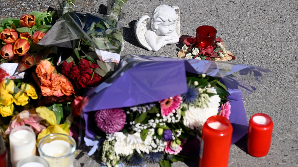 Zeichen der Anteilnahme: Auf einem Bürgersteig an dem Spielplatz sind Kerzen und Blumen niedergelegt worden. - Foto: Roberto Pfeil/dpa
