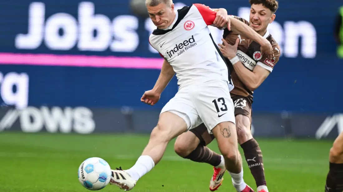 Eintracht Frankfurt um Arthur Theate (l) und der FC St. Pauli mit Manolis Saliakas lieferten sich eine wilde Anfangsphase. - Bild: Arne Dedert/dpa
