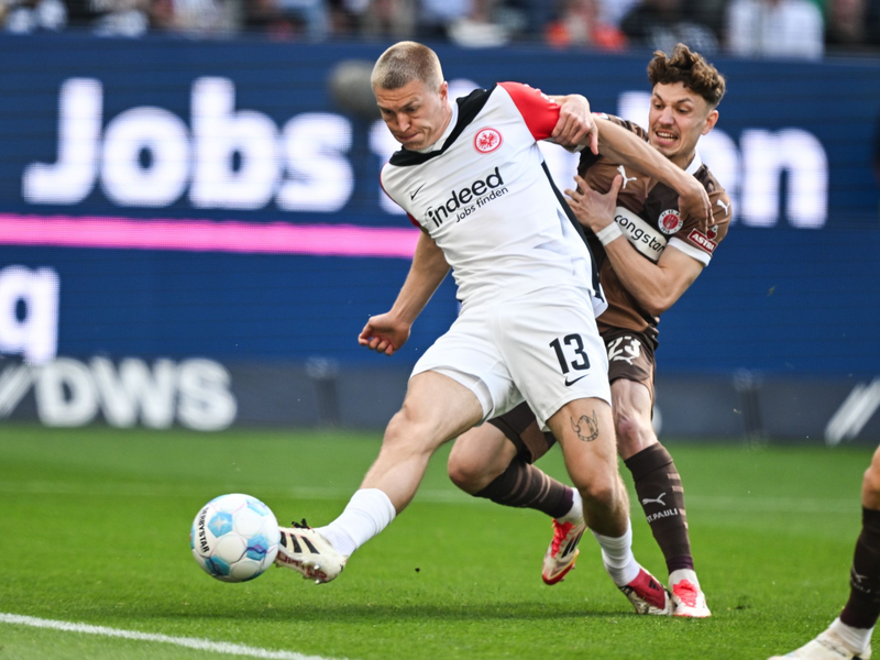 Eintracht Frankfurt um Arthur Theate (l) und der FC St. Pauli mit Manolis Saliakas lieferten sich eine wilde Anfangsphase. - Foto: Arne Dedert/dpa