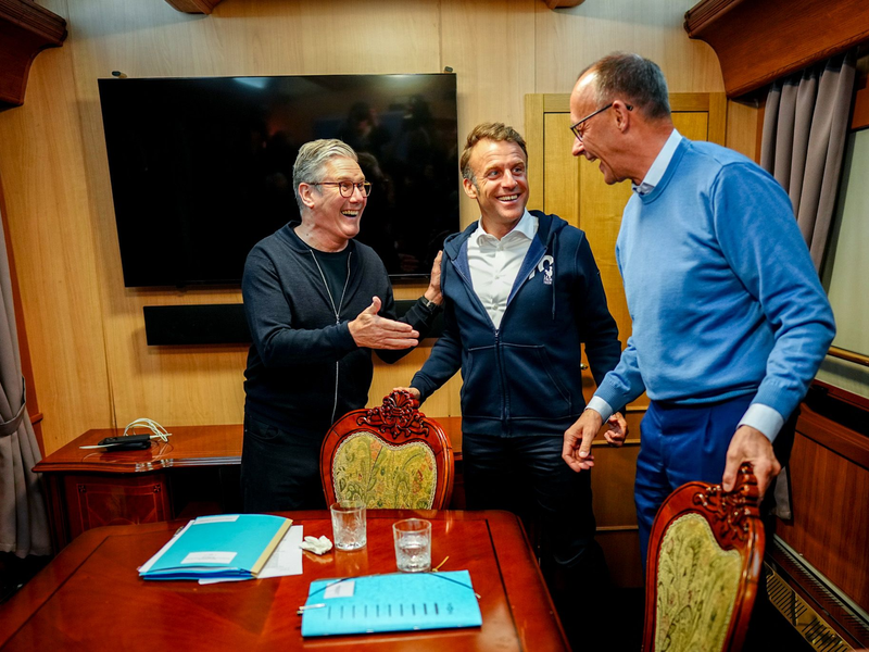 Auf dem Weg nach Kiew besprechen sich Präsident Emmanuel Macron, Bundeskanzler Friedrich Merz und Premierminister Keir Starmer - und wegen der anwesenden Presse räumt Macron noch schnell etwas vom Tisch, was später für Gerüchte sorgt.  - Foto: Kay Nietfeld/dpa