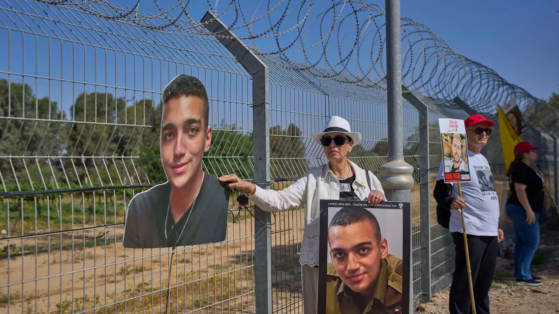 Angehörige zeigen an der Gaza-Grenze Bilder der US-israelischen Geisel Edan Alexander. (Archivbild) - Bild: Ohad Zwigenberg/AP/dpa